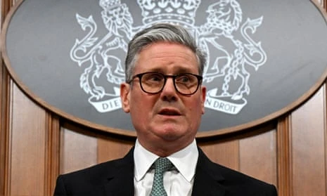 Keir Starmer looking worried in front of a brown wall and the UK coat of arms