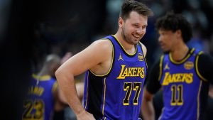 Los Angeles Lakers guard Luka Doncic laughs as he takes the court against the Denver Nuggets in the first half of an NBA basketball game Saturday, Feb. 22, 2025, in Denver.