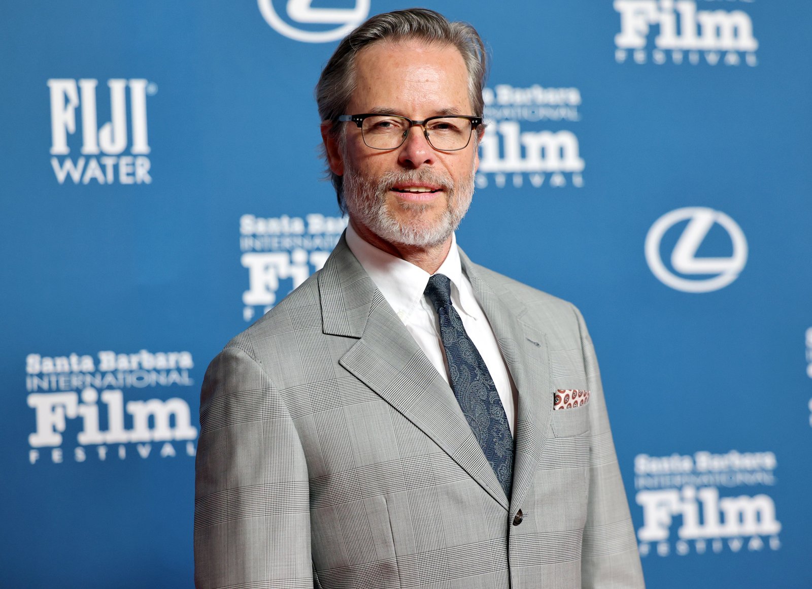 Guy Pearce poses in a gray suit and glasses during an appearance at the Santa Barbara International Film Festival.