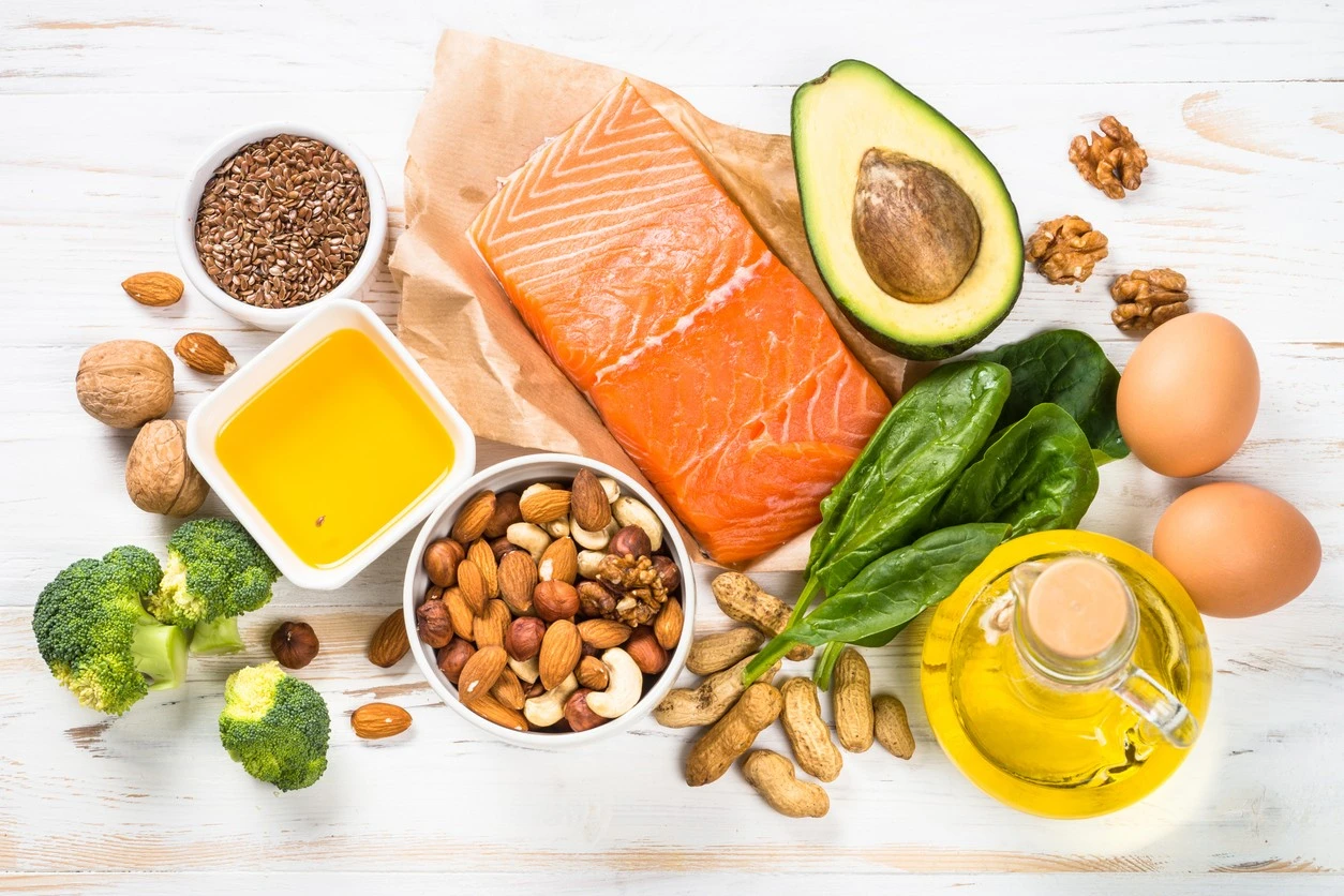 A variety of foods that are part of a keto diet, including salmon, avocado, broccoli and mixed nuts