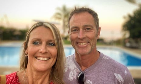 Smiling, tanned couple Lindsay and Craig Foreman in front of a pool