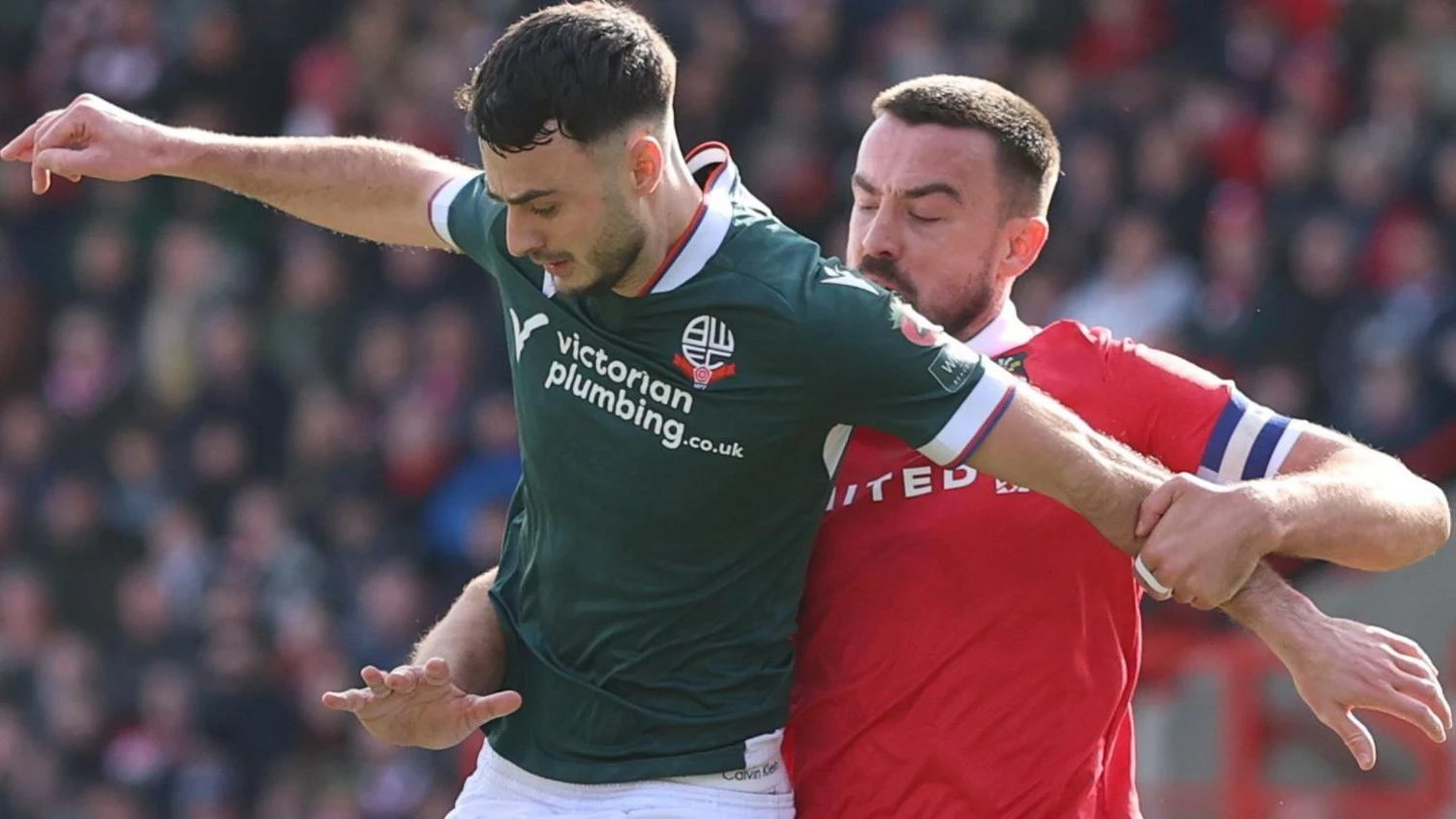 Aaron Collins of Bolton Wanderers and Eoghan O'Connell of Wrexham compete for the ball