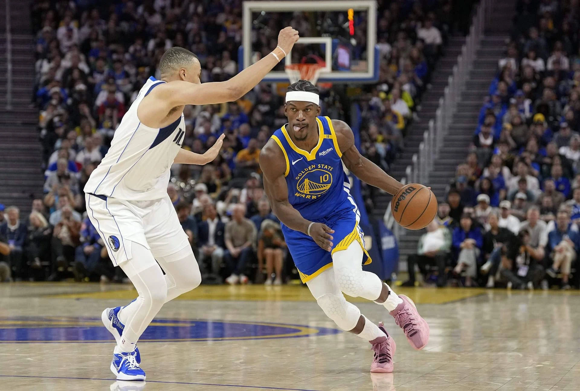 SAN FRANCISCO, CALIFORNIA - FEBRUARY 23: Jimmy Butler III #10 of the Golden State Warriors dribbles the ball to the basket on Dante Exum #0 of the Dallas Mavericks during the second half at Chase Center on February 23, 2025 in San Francisco, California.