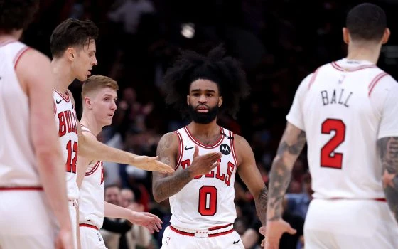 Bulls guard Coby White (0) is congratulated by teammates after hitting a 3-pointer while being fouled with four seconds left in regulation against the Raptors on Feb. 28, 2025, at the United Center. White made the free-throw attempt to force overtime, and the Bulls won 125-115. (Chris Sweda/Chicago Tribune)