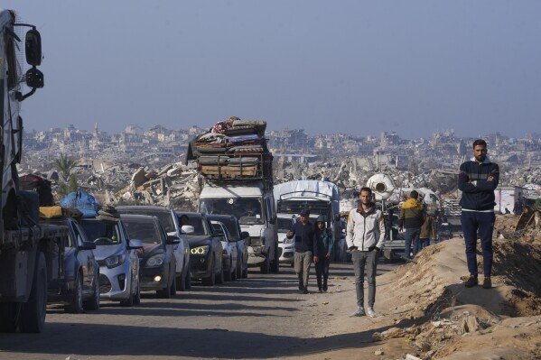 Displaced Palestinians, traveling in vehicles, wait to cross through a security checkpoint at the Netzarim corridor as they make their way from central Gaza to the northern Gaza Strip, Tuesday, Feb. 18, 2025. (AP Photo/Abdel Kareem Hana)