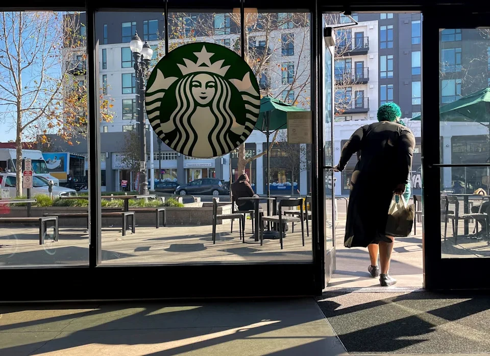 A customer exits a Starbucks store in Oakland, Calif., symbolizing the company's efforts to revitalize its customer experience and restore its community coffeehouse feel, as captured by AP Photo/Godofredo A. Vásquez, File, courtesy of Associated Press Finance.