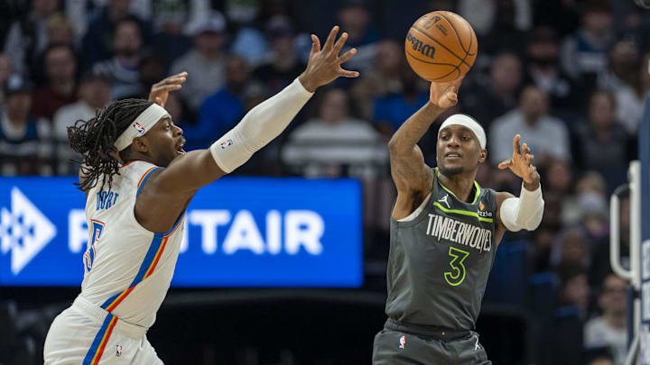 Minnesota Timberwolves forward Jaden McDaniels passes the ball around Oklahoma City Thunder guard Luguentz Dort in the first half at Target Center in Minneapolis on Feb. 23, 2025.