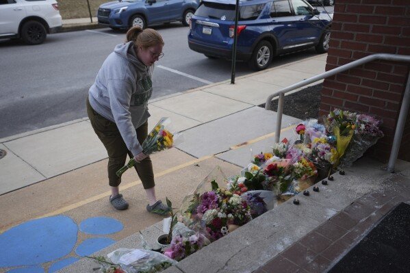 Leah Fauth places flowers in front of the West York Police Department after a police officer was killed responding to a shooting at UPMC Memorial Hospital in York, Pa. on Saturday, Feb. 22, 2025. (AP Photo/Matt Rourke)