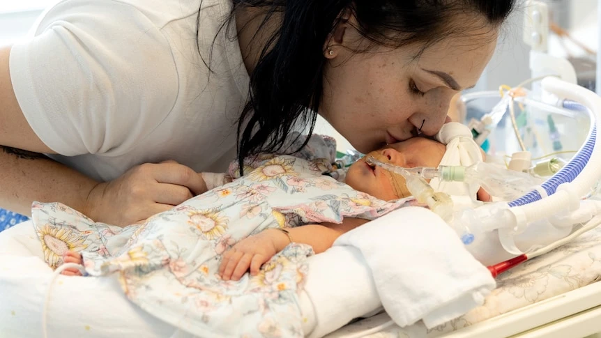 A woman kisses a baby.