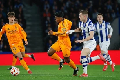 El delantero brasileño del Real Madrid, Endrick (c), se lleva el balón ante el centrocampista de la Real Sociedad, Luka Sucic, durante el partido de este miércoles.