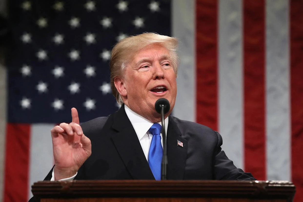 President Trump raises his index finger at the microphone.