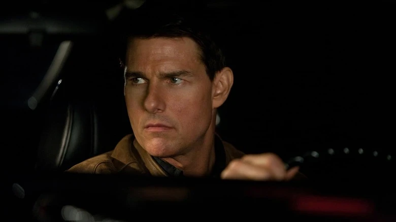 Tom Cruise as Jack Reacher staring intensely behind the wheel in Jack Reacher