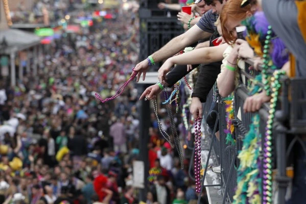 Revelers throw beads from the balcony of the Royal Sonesta Hotel onto crowds on Bourbon Street during Mardi Gras festivities in the French Quarter in New Orleans, March 8, 2011.