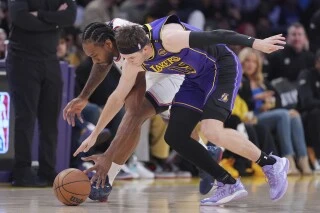 Los Angeles Clippers forward Kawhi Leonard, left, and Los Angeles Lakers guard Austin Reaves go after a loose ball during the first half of an NBA basketball game, Friday, Feb. 28, 2025, in Los Angeles. (AP Photo/Mark J. Terrill)