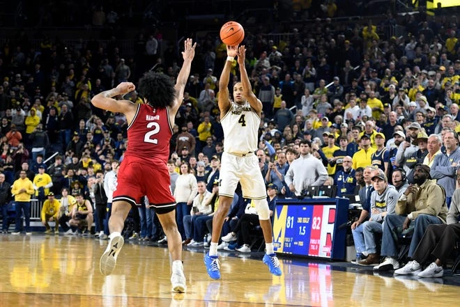 Michigan guard Nimari Burnett, right, shoots and makes a three-point shot over Rutgers guard Dylan Harper to win the game during the second half of an NCAA college basketball game, Thursday, Feb. 27, 2025, in Ann Arbor, Mich.