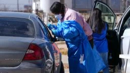 A health worker administers a measles test to a car passenger at a mobile testing site outside Seminole Hospital District Friday, Feb. 21, 2025, in Seminole, Texas. (AP Photo/Julio Cortez)