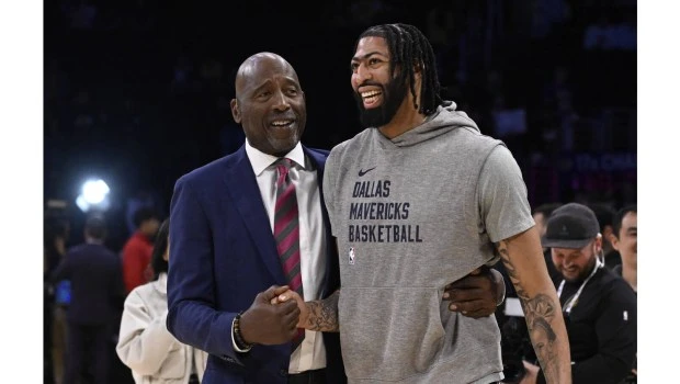 Dallas Mavericks star and former Laker Anthony Davis, right, is greeted by former Lakers star James Worthy before the Lakers and Mavericks squared off on Tuesday night at Crypto.com Arena.