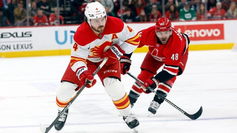 Calgary Flames' Rasmus Andersson (4) drives the puck around Carolina Hurricanes' Jordan Martinook (48) during the first period of an NHL hockey game in Raleigh, N.C., Sunday, March 2, 2025. (Karl DeBlaker/AP)