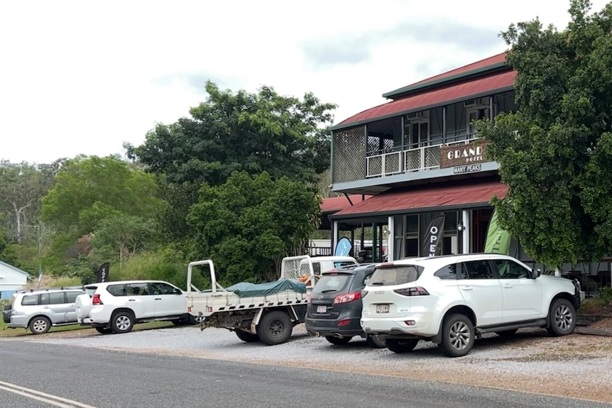 Cars parked in the street outside an old Queenslander-style pub