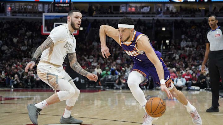 Feb 22, 2025; Chicago, Illinois, USA; Chicago Bulls guard Lonzo Ball (2) defends Phoenix Suns guard Devin Booker (1) during the first quarter at United Center.