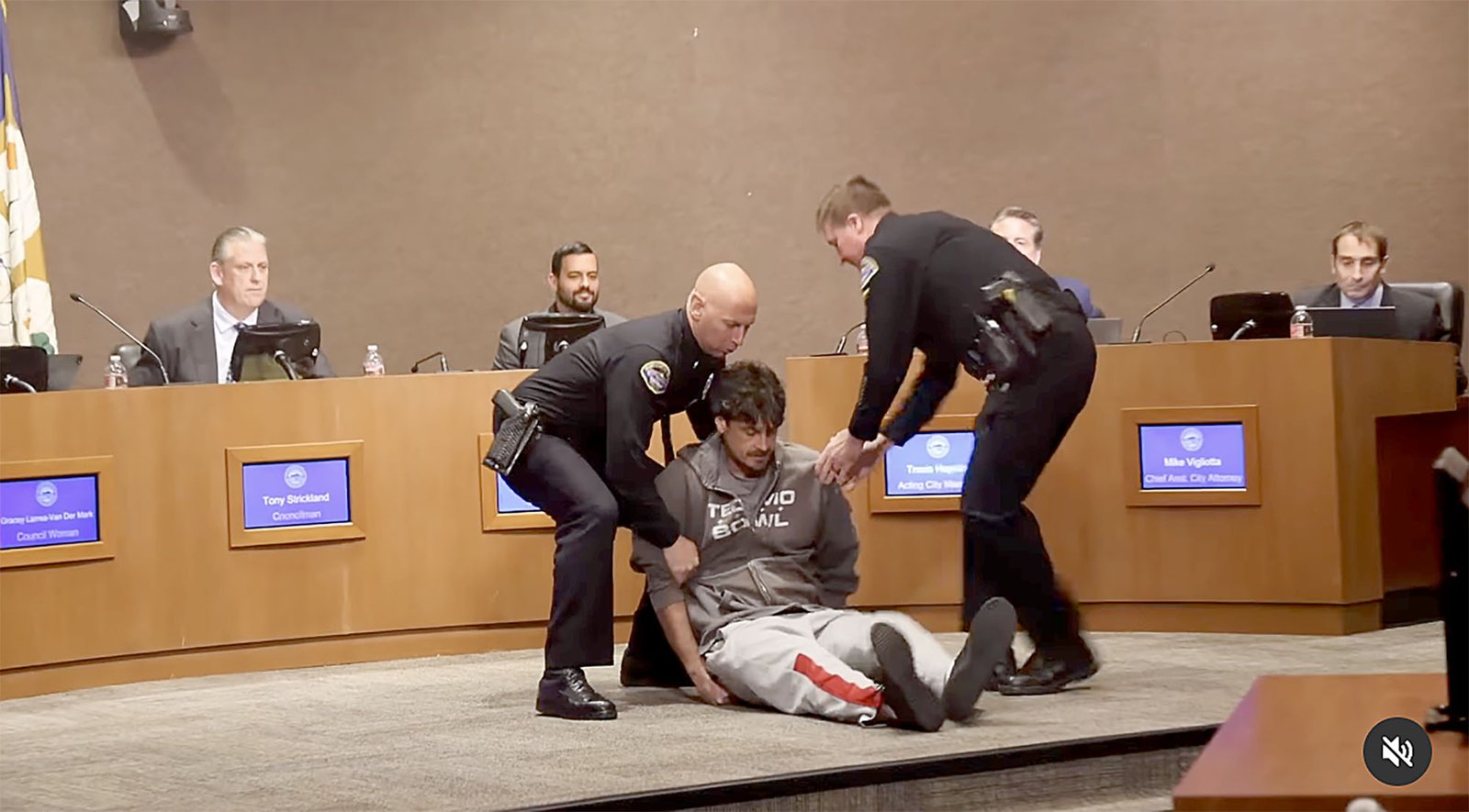 Chris Kluwe is taken into custody by police officers after walking toward the Huntington Beach City Council dais in what he described as an act of peaceful civil disobedience. (Protect HB)