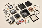 A teardown of a mini PC with all its components laying on a light beige surface.