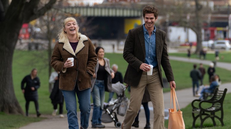 Andrew Garfield and Florence Pugh as Tobias and Almut laughing in park in We Live in Time,