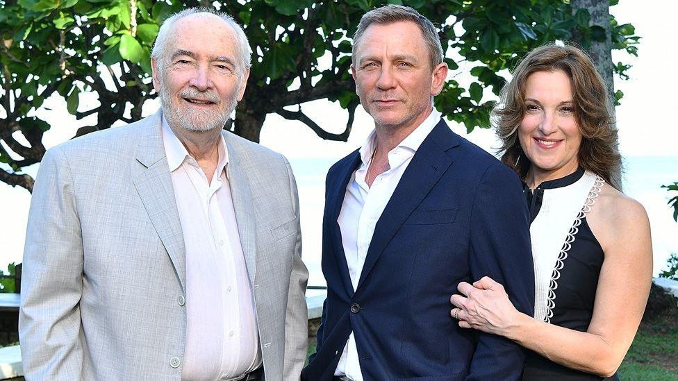 Daniel Craig standing between Michael G Wilson and Barbara Broccoli