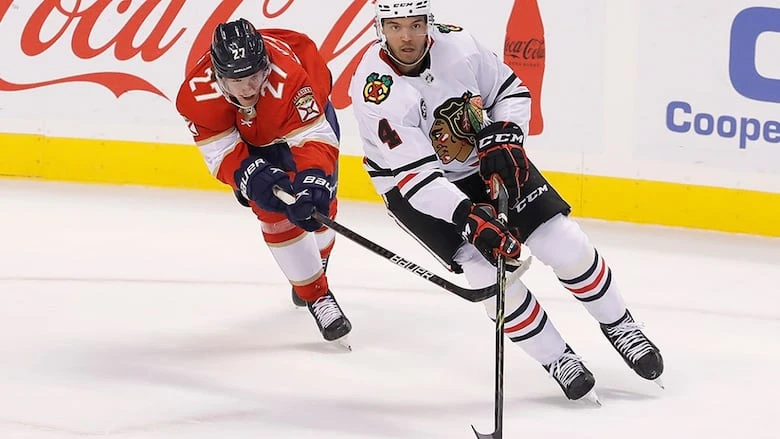 Florida Panthers centre Eetu Luostarinen tries to slow down Chicago Blackhawks defenceman Seth Jones during the first period of an NHL regular-season game on March 31, 2022, in Sunrise, Florida.