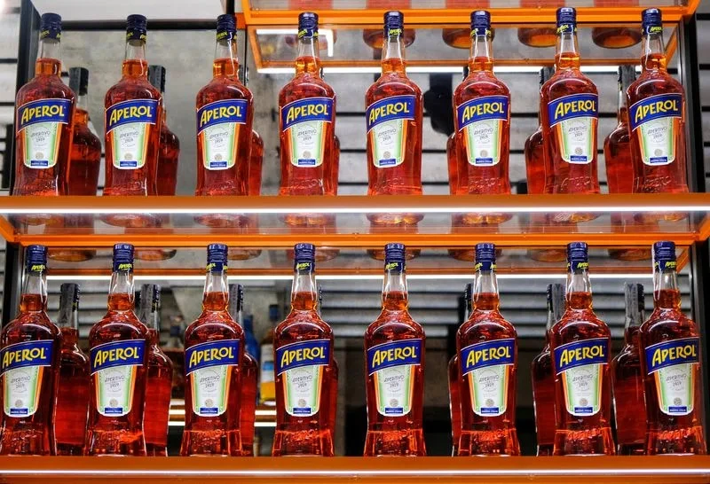 As the sun sets over the canals of Venice, Italy, bottles of Aperol are displayed at the Campari inauguration of a new brand house, a symbol of the company's commitment to its best-selling beverage. (Photo credit: Reuters)