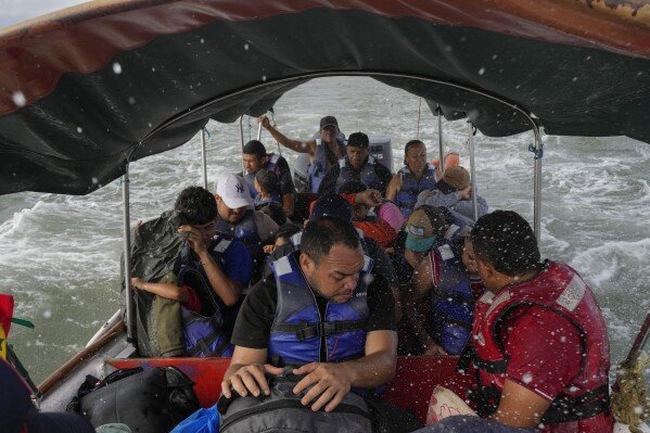 Luis Sanchez, center, sits with other Venezuelan migrants on a boat leaving Gardi Sugdub on Panama's Caribbean coast, Sunday, Feb. 23, 2025, after giving up hopes of reaching the U.S. while in southern Mexico amid President Trump's crackdown on migration. (AP Photo/Matias Delacroix)