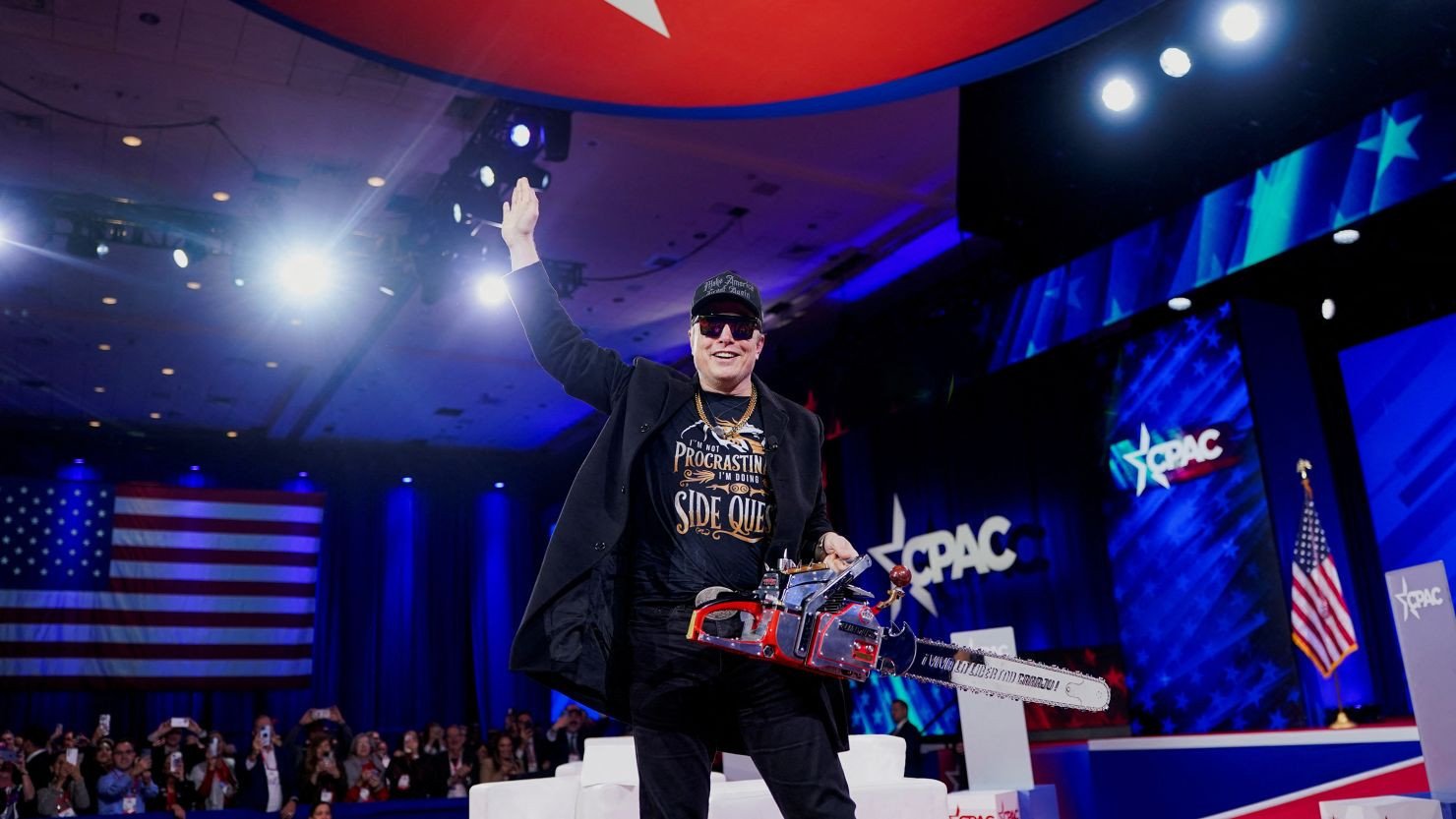 Elon Musk holds a chainsaw onstage as he attends the Conservative Political Action Conference (CPAC) in National Harbor, Maryland, U.S., February 20, 2025.