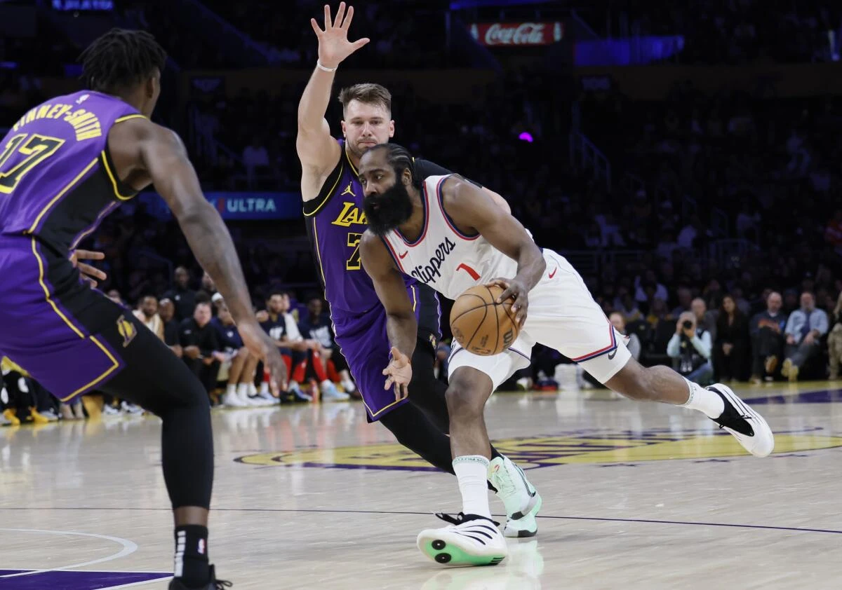 Clippers guard James Harden drives past Lakers guard Luka Doncic during the first quarter action Friday night.