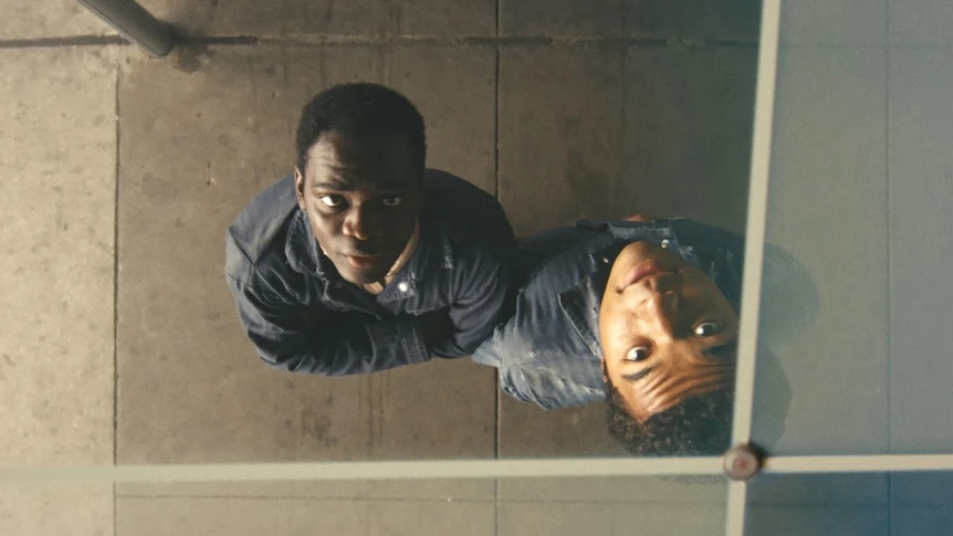 Two young men look up towards the camera.