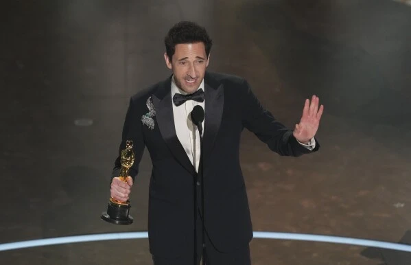 Adrien Brody accepts the award for best performance by an actor in a leading role for "The Brutalist" during the Oscars on Sunday, March 2, 2025, at the Dolby Theatre in Los Angeles. (AP Photo/Chris Pizzello)