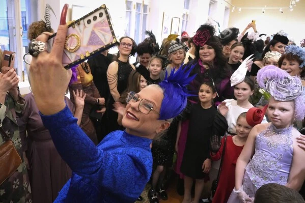 Women take selfie photos while they participate in the flash mob "Beautiful secular outing" by wearing hats to a performance at the St. Petersburg State Academic Capella celebrating upcoming International Women's Day, in St. Petersburg, Russia, Thursday, March 6, 2025. (AP Photo/Dmitri Lovetsky)