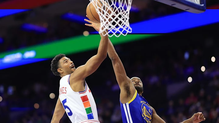 Mar 1, 2025; Philadelphia, Pennsylvania, USA; Philadelphia 76ers guard Quentin Grimes (5) scores past Golden State Warriors guard Moses Moody (4) during the first quarter at Wells Fargo Center. Mandatory Credit: Bill Streicher-Imagn Images