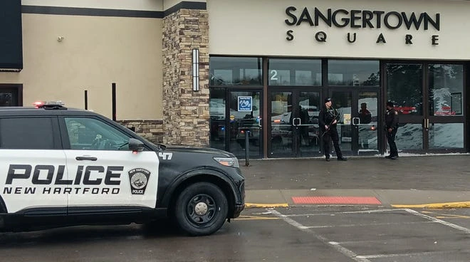 Police stand outside Sangertown Square Mall after a shooting incident on Saturday.