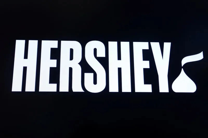 The Hershey Co. logo is displayed prominently on the floor of the New York Stock Exchange, a symbol of the company's commitment to quality and integrity - but behind the scenes, the company is fighting for a fair and transparent cocoa market, as reported by Reuters, with the company logo displayed on a screen on the floor of the NYSE in New York.