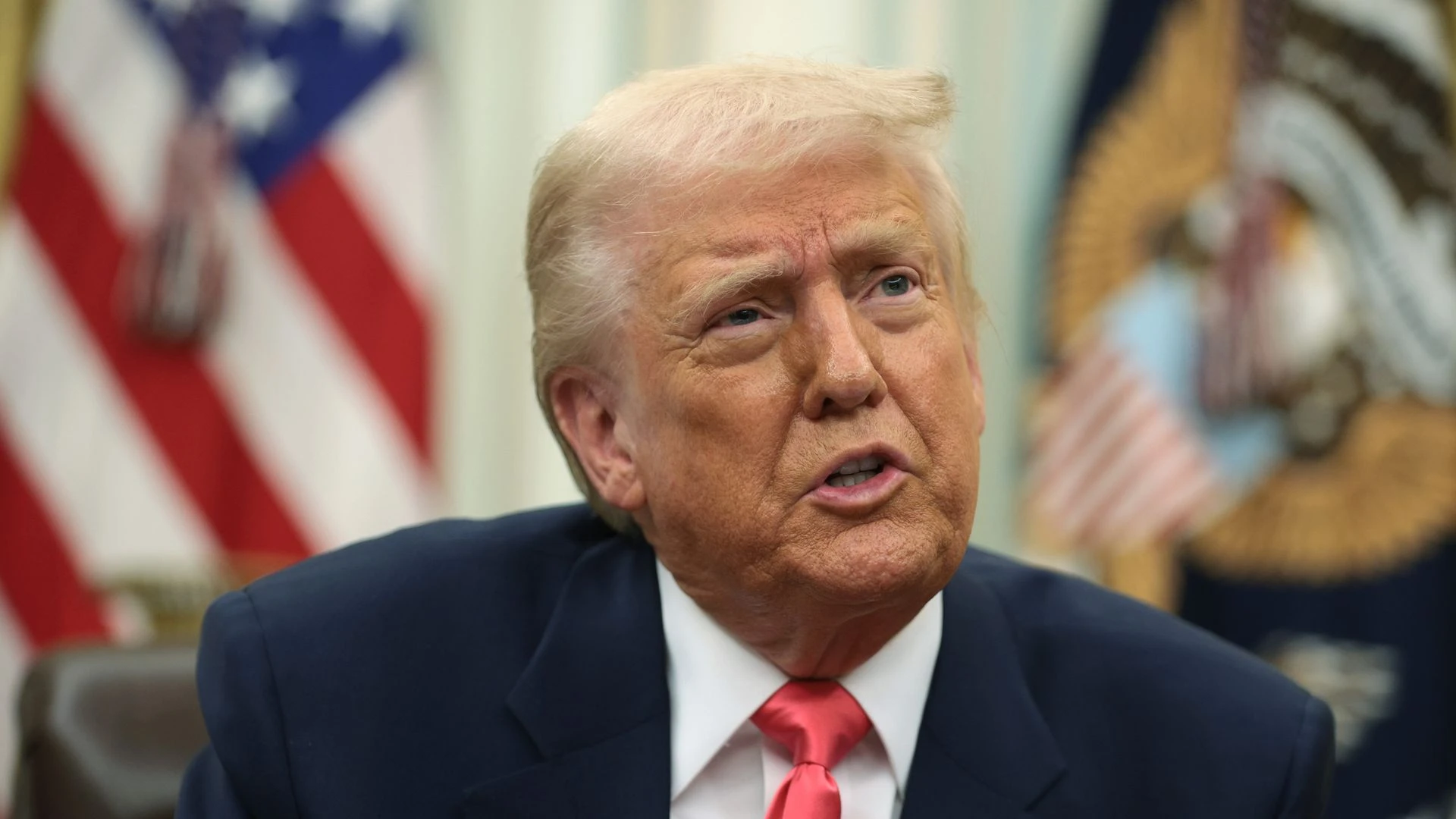 President Trump speaking from the White House. Flags are seen behind him