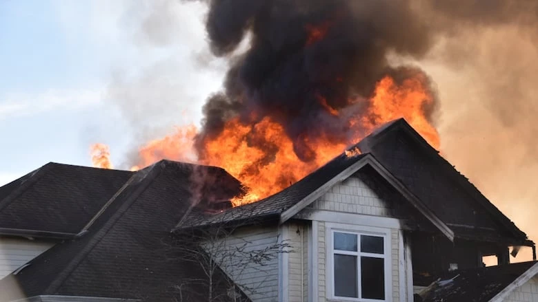 The upper portion of a Langley, B.C., home is engulfed in flames.