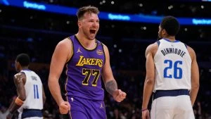 Los Angeles Lakers guard Luka Doncic (77) reacts next to Dallas Mavericks guard Spencer Dinwiddie (26) after scoring an drawing a foul during the first half of an NBA basketball game Tuesday, Feb. 25, 2025, in Los Angeles.