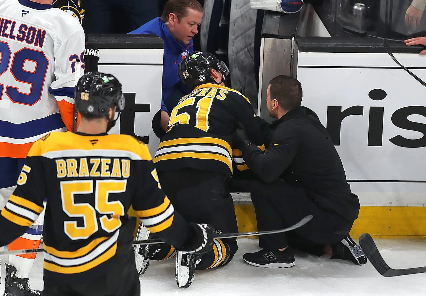 Bruins center Matthew Poitras was injured after being checked into the Islanders's open bench door in the second period.