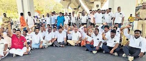 BJP cadre staging a road roko claiming that the police removed the banners installed by them to welcome Shah and took them in garbage collection vehicles