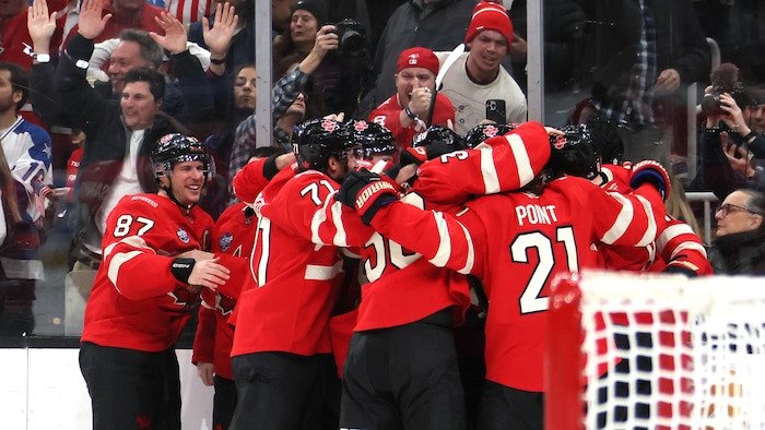 Des joueurs de hockey célèbrent sur la glace.