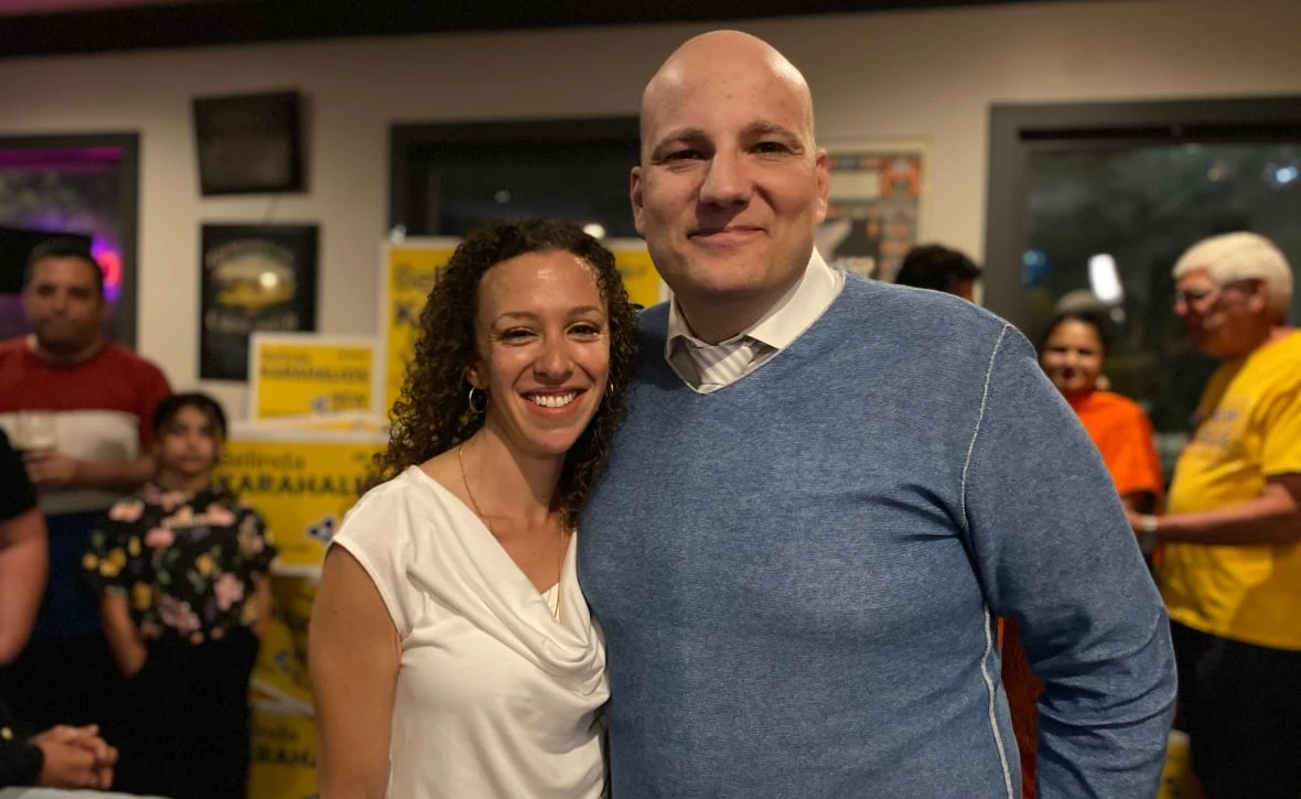 A woman and man pose for a photo at a political post-election gathering