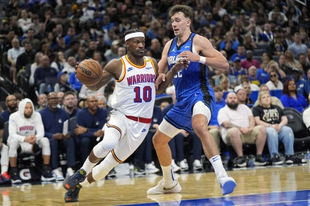 Golden State Warriors forward Jimmy Butler (10) drives past Orlando Magic forward Franz Wagner, right, during the second half of an NBA basketball game, Thursday, Feb. 27, 2025, in Orlando, Fla. (AP Photo/John Raoux)