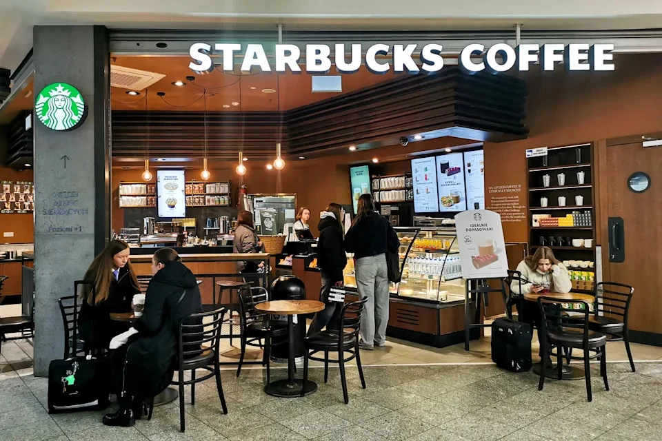 A bustling Starbucks store in a shopping center in Krakow, Poland, serves as a backdrop for the company's ongoing efforts to revamp its brand and regain customer loyalty, as captured by Beata Zawrzel/NurPhoto via Getty Images.