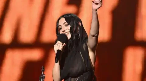 Getty Images Charli XCX collecting one of five awards