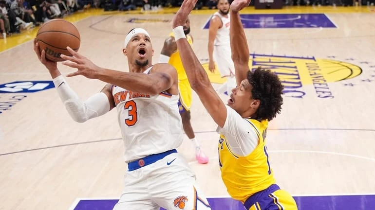 Knicks guard Josh Hart, left, shoots as Los Angeles Lakers...